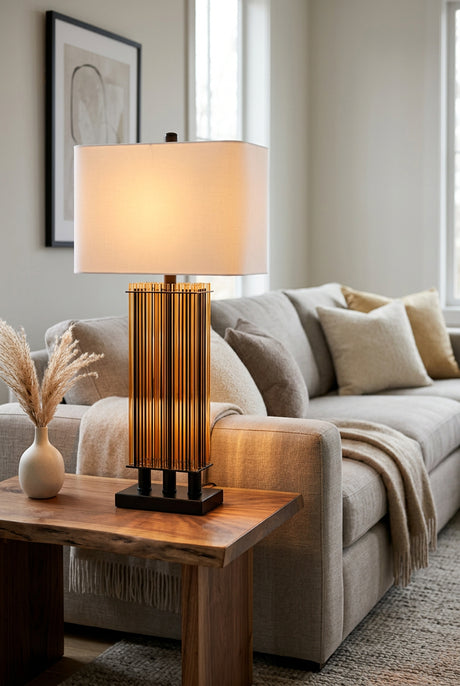 Orsina Table Lamp with a modern design featuring a warm glow, placed beside a cozy sofa