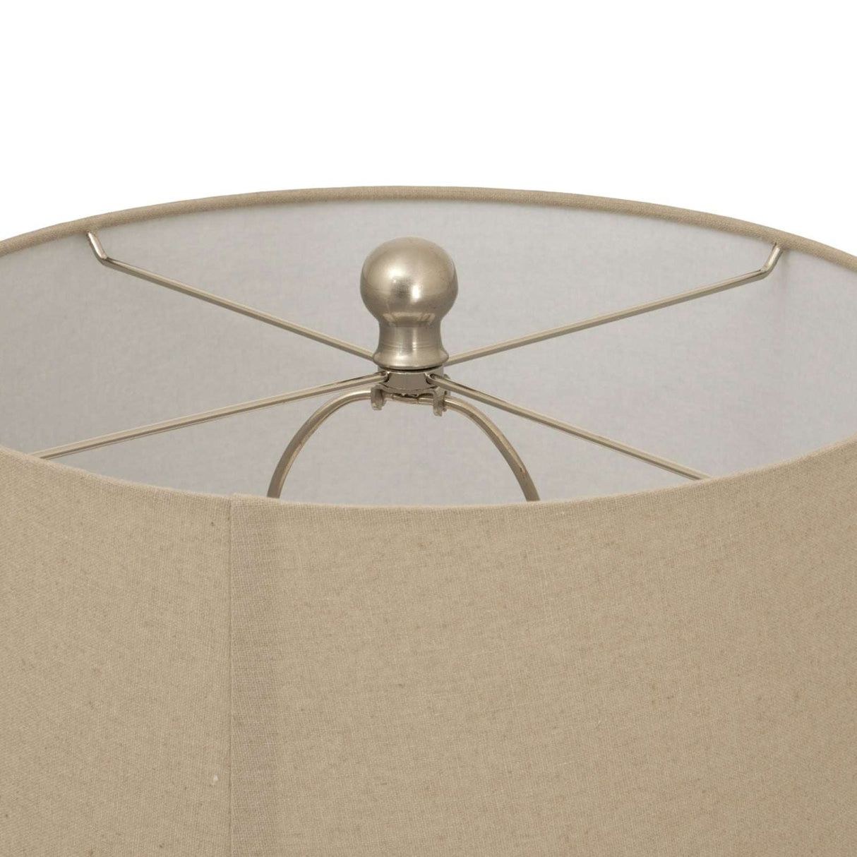 Close-up of a ceramic table lamp with a beige lampshade and metal support structure