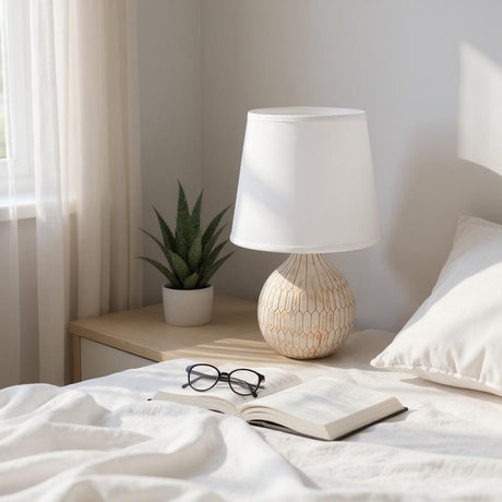 MSL Table Lamp with a textured base and a white shade placed on a bedside table with a plant and book