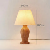 Nisu Home Table Lamp with a woven design featuring a cream fabric shade and natural finish