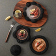 Stylish Nisu Home tableware set featuring elegant black stone dishes and wooden serving board