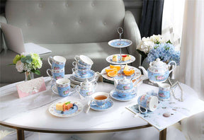 Beautiful blue floral tea set displayed on a table with a cake stand showcasing desserts