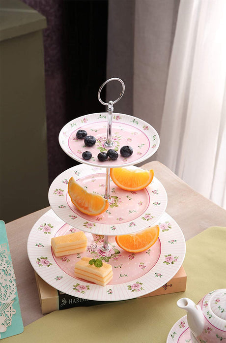 Elegant three-tier cake stand with floral design, featuring fruit and pastries arranged beautifully