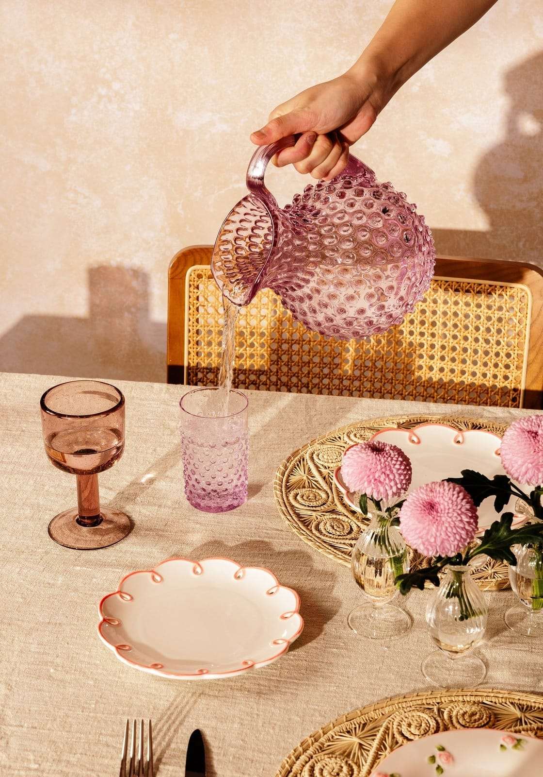 Casa by Josephine Jenno decorative side plates on a dining table with pink flowers and glassware