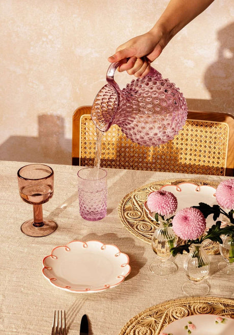 Casa by Josephine Jenno decorative side plates on a dining table with pink flowers and glassware