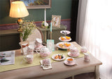 Elegant tea cups set on a beautifully arranged table with pastries and fruits for afternoon tea