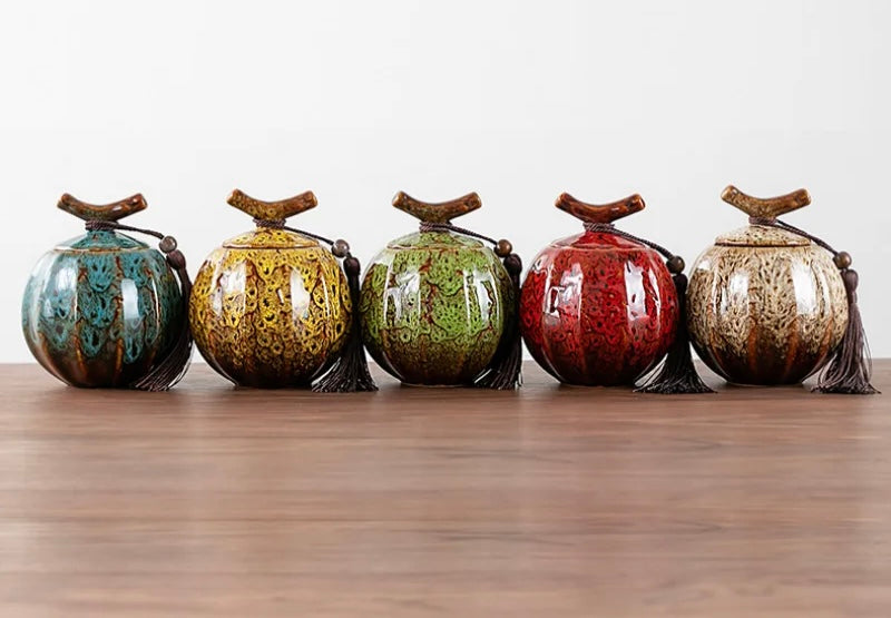Handcrafted ceramic tea jars in five vibrant colours with decorative tassels and wooden lids