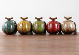Handcrafted ceramic tea jars in five vibrant colours with decorative tassels and wooden lids