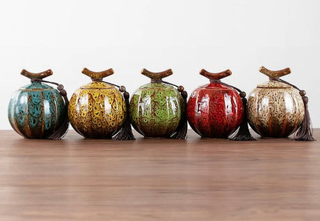 Handcrafted ceramic tea jars in five vibrant colours with decorative tassels and wooden lids