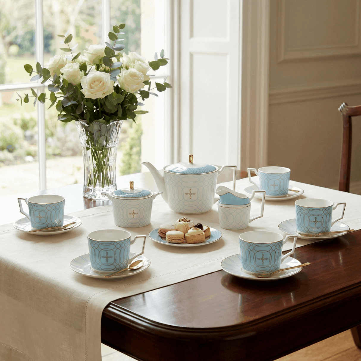 KitchBoom elegant Tea Set with blue patterned cups and teapot on a wooden dining table