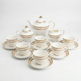 Elegant KitchBoom Tea Set featuring a teapot, cups, and saucers with a gold Greek key design
