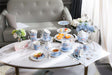 Elegant tea set display featuring a Sugar Bowl and assorted pastries on a stylish coffee table
