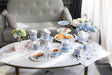 Elegant tea set display featuring a Sugar Bowl and assorted pastries on a stylish coffee table