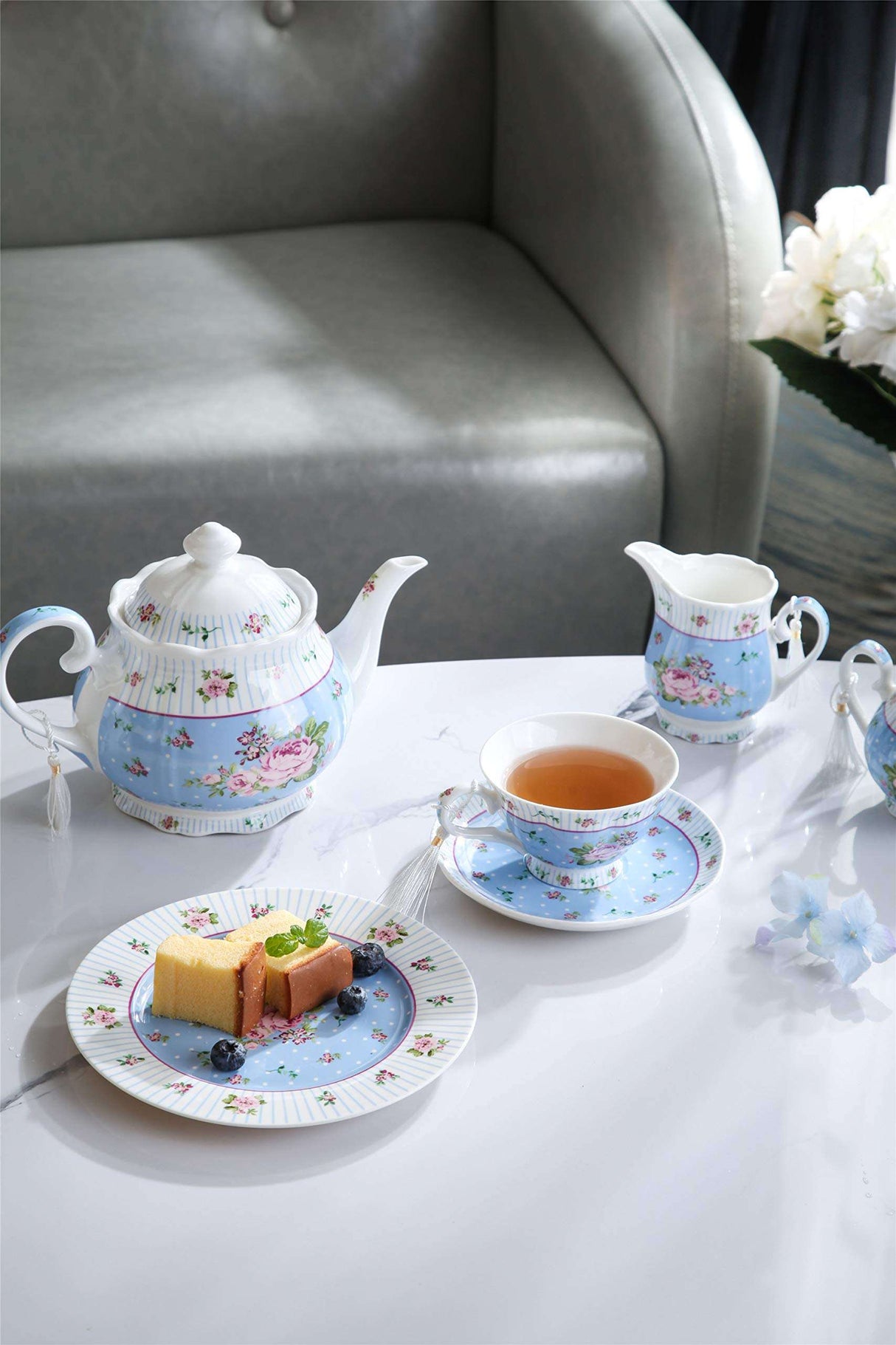 Elegant Teapot Set with Floral Design, Accompanied by Cup and Saucer on a Stylish Table