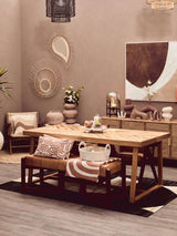 Stylish terracotta throw draped over a bench in a modern dining area with earthy decor