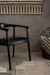 Orsina Textured Rug in neutral tones, complementing modern decor with a stylish chair and woven throw