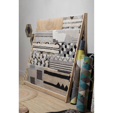 Collection of Orsina Textured Rugs displayed on a wooden stand showcasing various patterns and colours