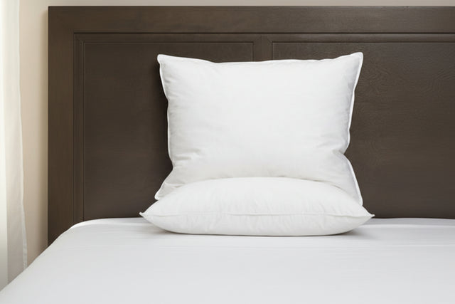 White Pillow from PillowPillow on a bed with a wooden headboard for comfort and support