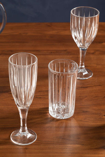 Elegant Orsina Wine Glasses set on a wooden table, showcasing their ribbed design and clear finish