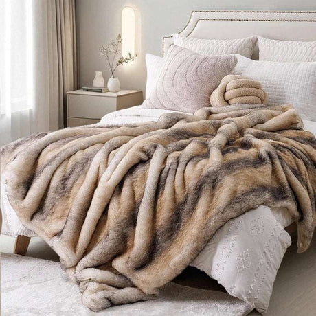 Plush beige and cream throw blanket draped elegantly on a bed for a cosy home decor look