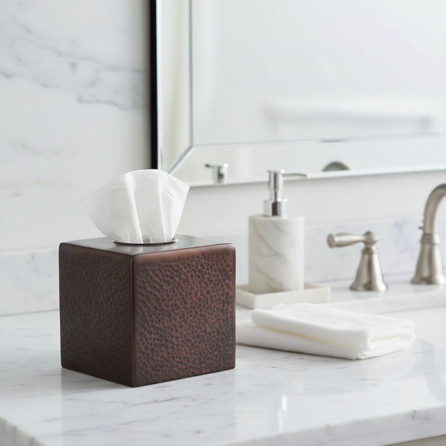Orsina Tissue Box in brown leather design on a bathroom countertop with towels and soap dispenser