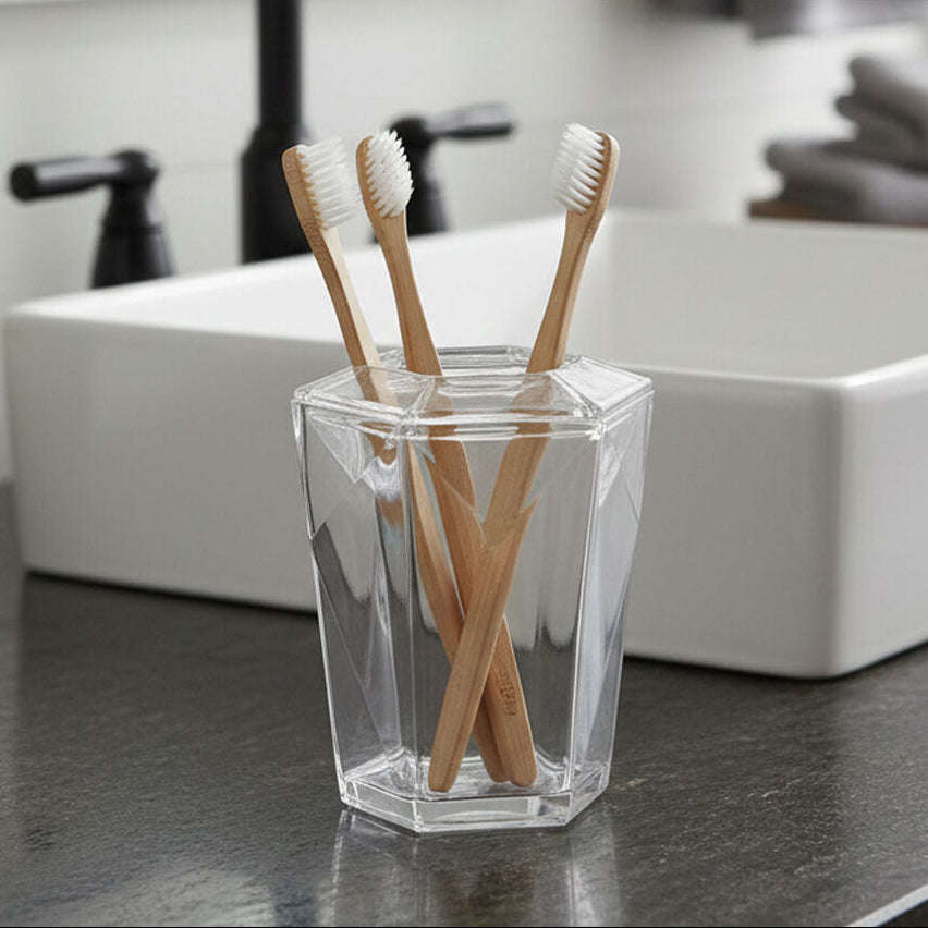 Orsina Toothbrush Holder with three bamboo toothbrushes in a clear geometric container