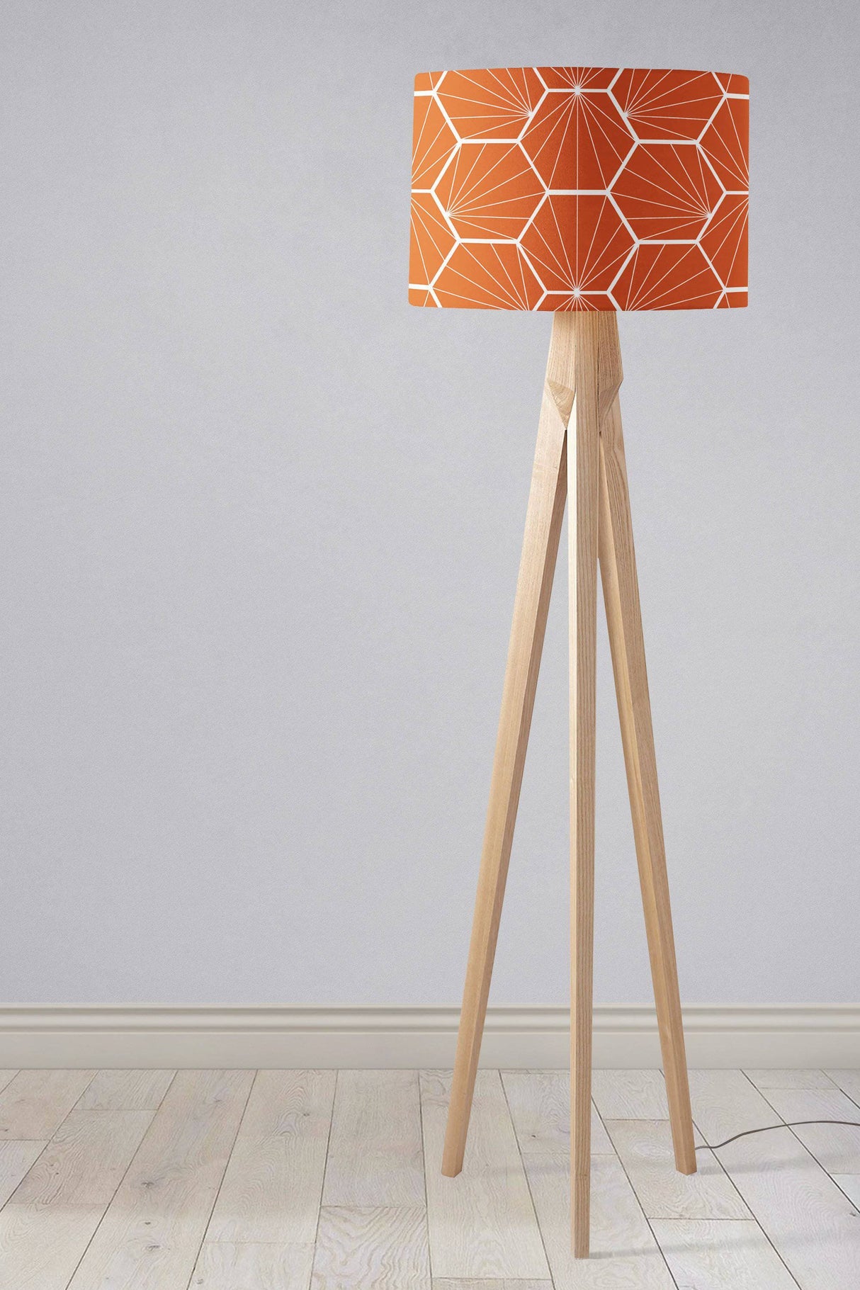 Stylish Shadow Bright lampshade in orange geometric pattern on a wooden tripod floor lamp