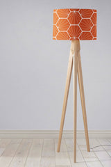 Stylish Shadow Bright lampshade in orange geometric pattern on a wooden tripod floor lamp