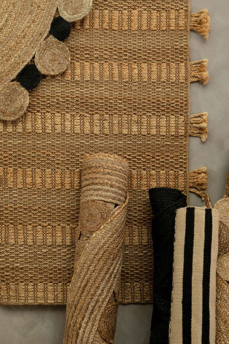 Orsina Trenza Rug featuring a textured natural design with tassels and rolled rugs in various patterns