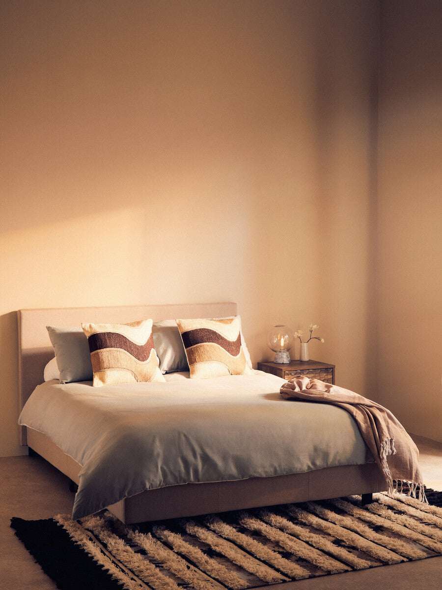 Orsina Tribal Rug on the floor beneath a stylish bedroom with neutral tones and modern decor
