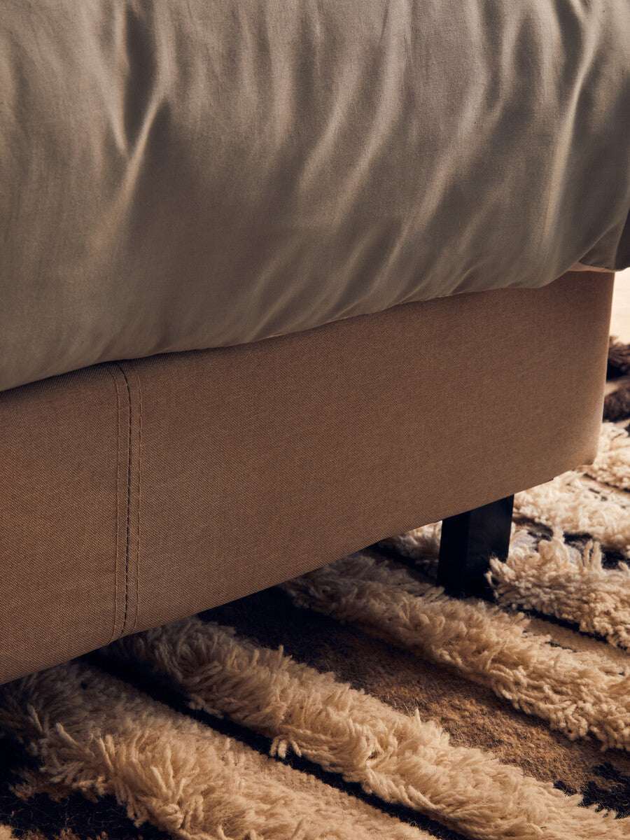 Orsina Tribal Rug featuring soft, textured fibres under a bed for a cozy home aesthetic