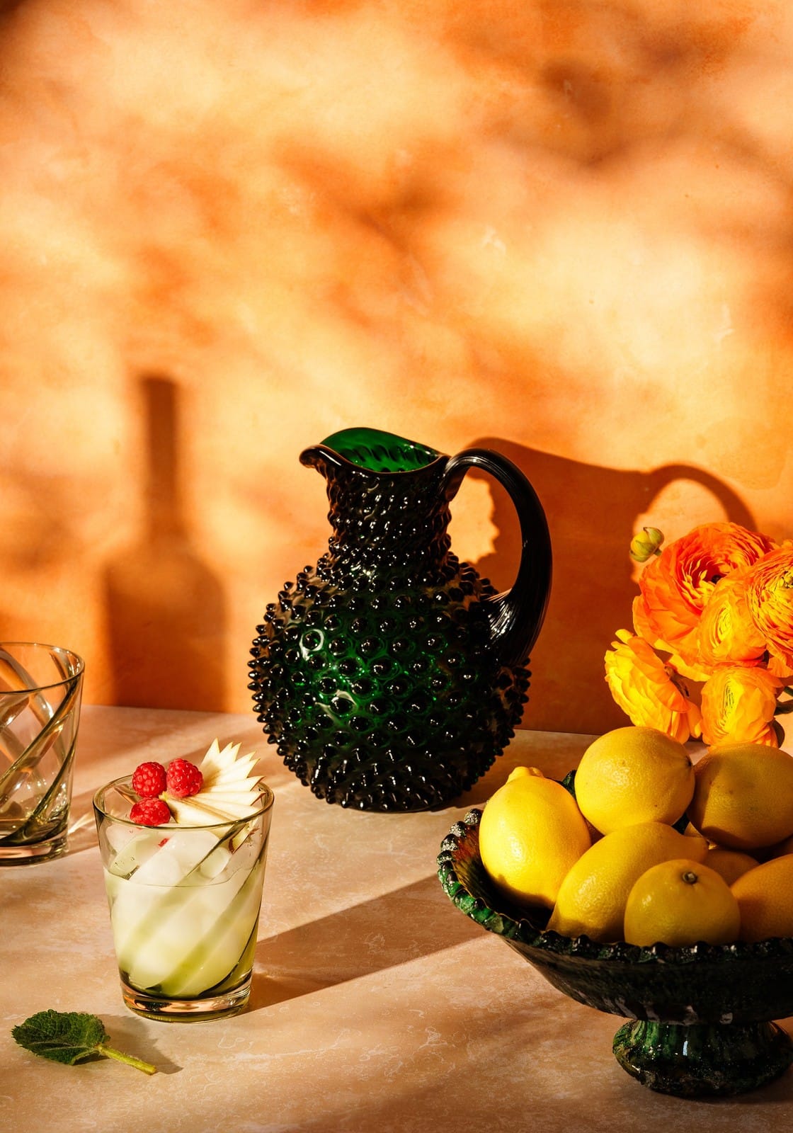 Casa by Josephine Jenno Green Tumbler Glass with Fresh Fruits and Decorative Pitcher on Table