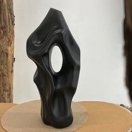 Modern black vase from Nisu Home with an abstract shape and an oval cut-out design