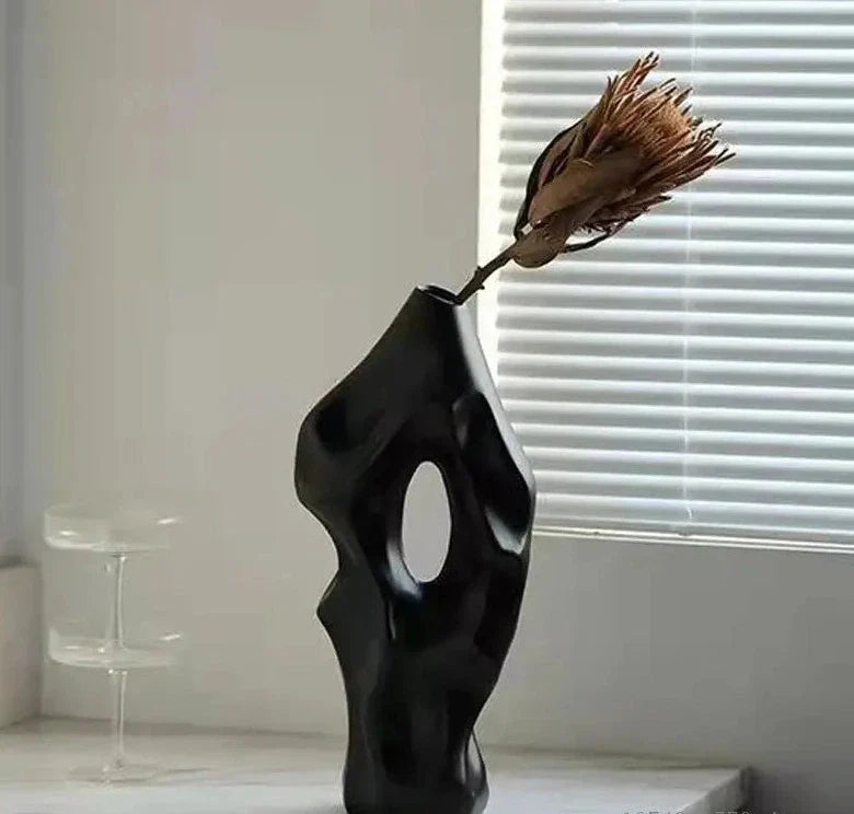 Elegant black ceramic vase with an unique shape, featuring dried flowers for stylish home decor