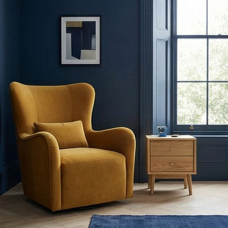 Stylish Fishe and Lilly Bedside Table in natural wood next to a modern armchair and blue wall