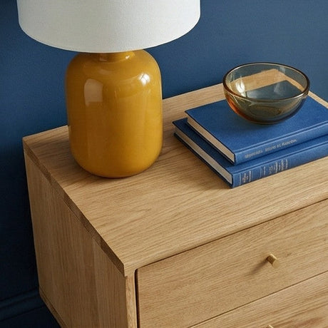 Fishe and Lilly Bedside Table with a yellow lamp and stacked books for stylish bedroom decor