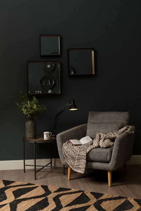 Stylish Orsina Hemp Rug placed under a modern armchair with a book and cozy blanket in a chic living space