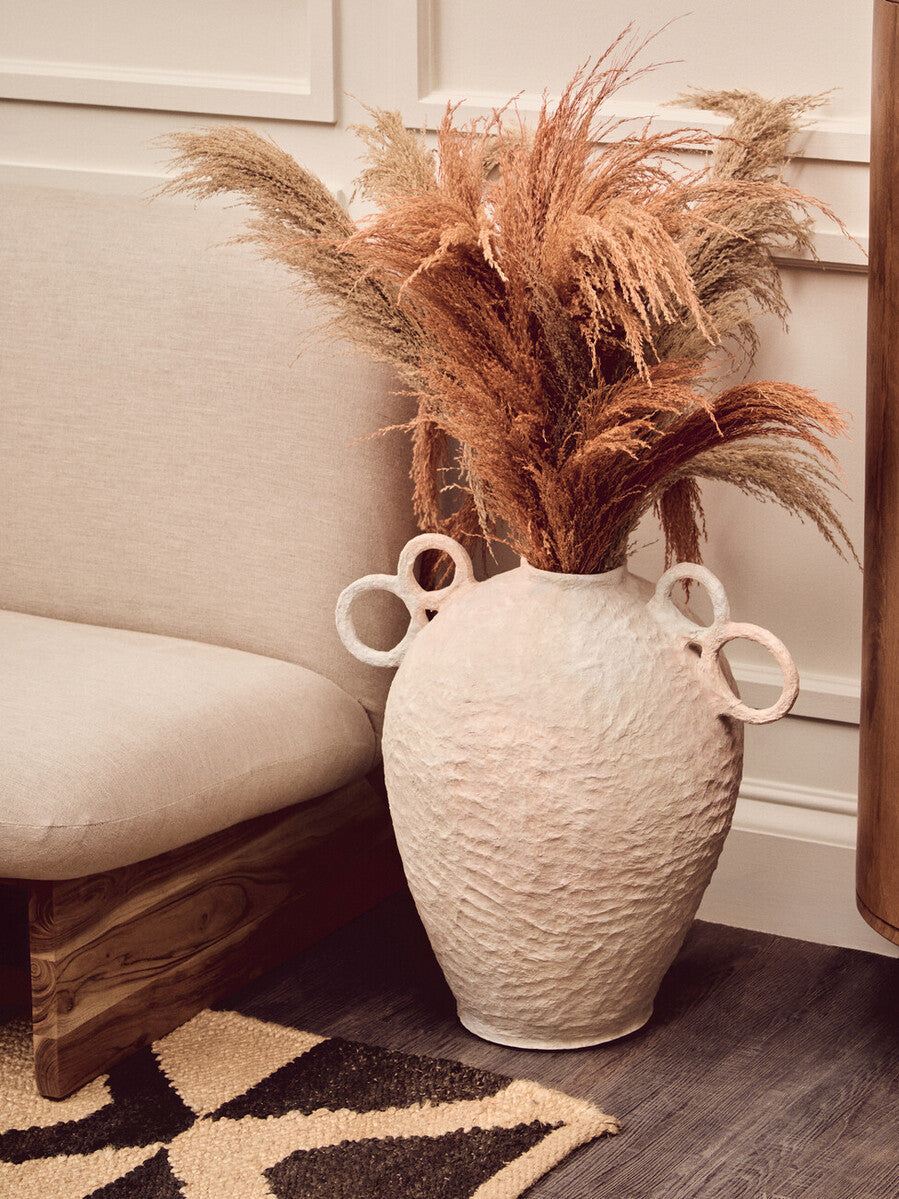 Stylish living room featuring a Hemp Rug with a decorative vase of dried flowers and modern seating