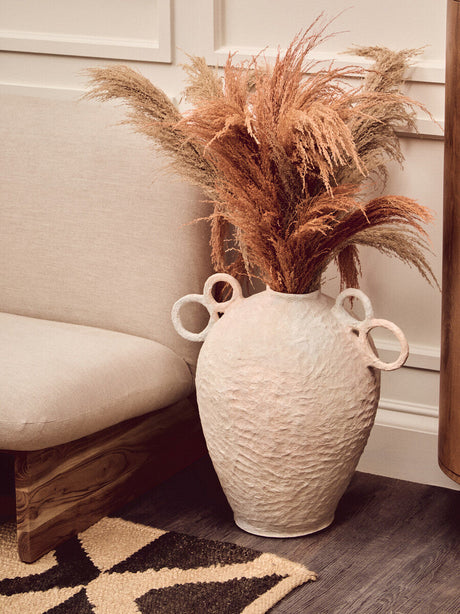 Stylish living room featuring a Hemp Rug with a decorative vase of dried flowers and modern seating