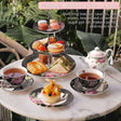 Vintage shabby chic cake stand with matching teacups and plates for an elegant afternoon tea experience