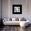 Modern abstract wall art canvas featuring geometric shapes in black and white above a stylish sofa
