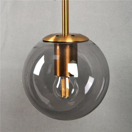 Stylish pendant Wall Light with a transparent globe and brass fixture for modern interiors