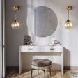 Stylish wall light fixture in a modern dressing area with a round mirror and elegant chair