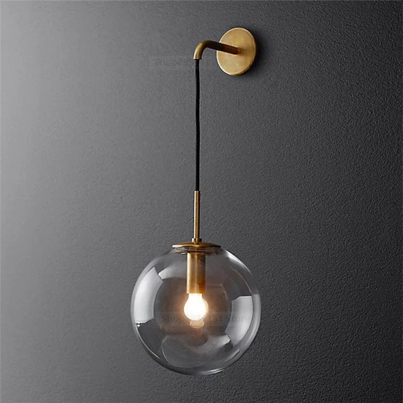 Elegant brass wall light featuring a clear glass globe for modern home decor