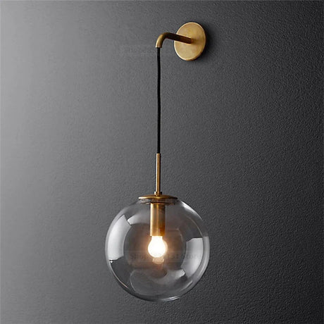 Elegant brass wall light featuring a clear glass globe for modern home decor