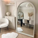 Stylish Nisu Home Wall Mirror in an arched frame reflecting a modern living space with soft furnishings