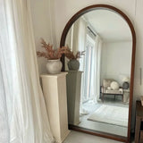 Elegant Nisu Home Wall Mirror with a wooden frame, reflecting a stylish room interior