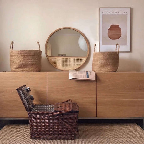 Nisu Home Wall Mirror with a Circular Design Above a Wooden Sideboard and Natural Baskets