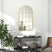 Elegant wall mirror with arched design and gold frame, enhancing any bathroom decor