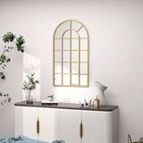 Stylish gold-framed wall mirror in an arch design above a modern sideboard for elegant bathroom decor